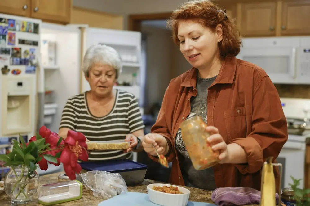 A younger woman and an older woman cooking together in a home kitchen